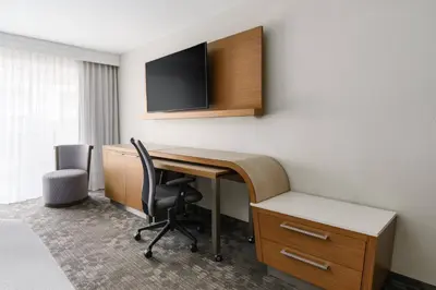 a room with a desk and a tv on a wall at Courtyard by Marriott Orlando Lake Buena Vista at Vista Centre in Orlando