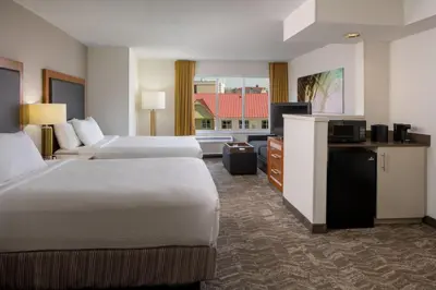 a hotel room with two beds and a flat screen tv at SpringHill Suites by Marriott Orlando Convention Center in Orlando