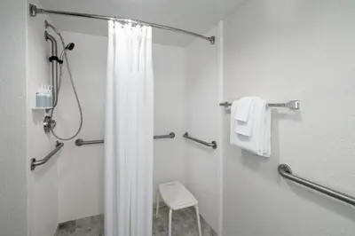 a bathroom with a shower with a white shower curtain at SpringHill Suites by Marriott Orlando Convention Center in Orlando