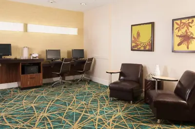 a waiting room with chairs and a desk and monitors at SpringHill Suites by Marriott Orlando Convention Center in Orlando