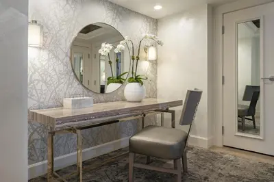 a bathroom with a vanity with a mirror and a chair at Hyatt Regency Orlando International Airport Hotel in Orlando