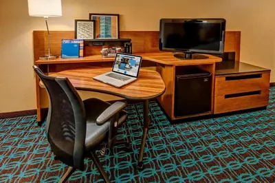a room with a desk with a laptop and a tv at Fairfield Inn and Suites by Marriott Orlando Near Universal Orlando in Orlando