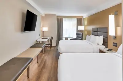 a hotel room with two beds and a desk at AC Hotel by Marriott Orlando Lake Buena Vista in Orlando