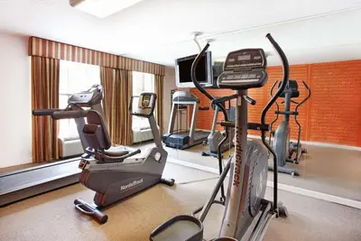 a gym with two exercise bikes and a television at La Quinta Inn by Wyndham Orlando International Drive North in Orlando
