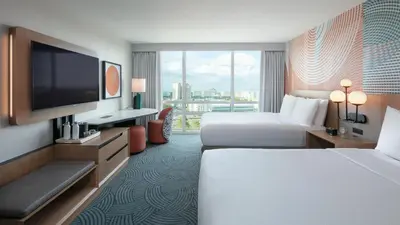 a hotel room with two beds and a flat screen tv at Hotel Landy Orlando Universal Blvd, a Tribute Portfolio Hotel in Orlando
