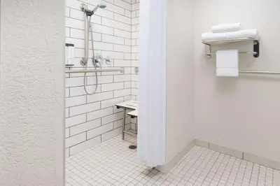 a white bathroom with a shower and a sink at Hyatt Place Orlando / I-Drive / Convention Center in Orlando