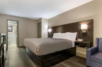 a hotel room with a bed and a blue chair at Quality Inn & Suites Altamonte Springs Orlando-North in Orlando