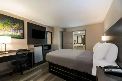 a hotel room with a bed and a desk with a computer at Quality Inn & Suites Altamonte Springs Orlando-North in Orlando