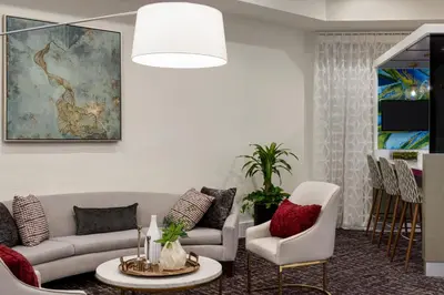 a living room with a couch and a table and chairs at Crowne Plaza Orlando - Lake Buena Vista by IHG in Orlando