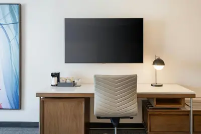 a desk with a chair and a television on a wall at Courtyard by Marriott across Universal Orlando in Orlando