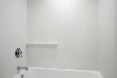 a white bathroom with a tub and a sink at Courtyard by Marriott across Universal Orlando in Orlando
