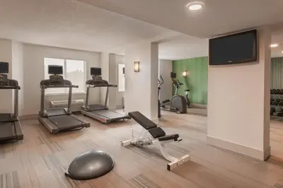 a gym with several exercise bikes and a flat screen tv at Holiday Inn Express & Suites - Nearest Universal Orlando by IHG in Orlando