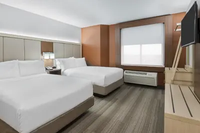 a hotel room with two beds and a flat screen tv at Holiday Inn Express & Suites - Nearest Universal Orlando by IHG in Orlando