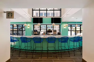 a bar in a restaurant with blue chairs at Sonesta ES Suites Orlando International Drive in Orlando