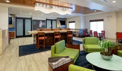 a lobby with a bar and chairs and a table at Holiday Inn Express-International Drive by IHG in Orlando