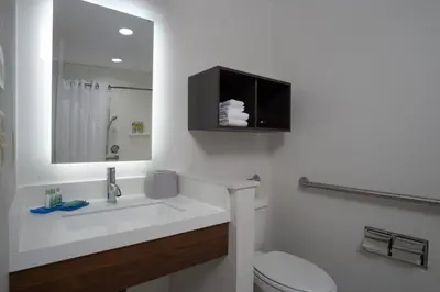 a bathroom with a sink and a toilet and a mirror at Holiday Inn Express-International Drive by IHG in Orlando