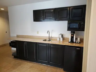 a kitchen with black cabinets and a sink at Holiday Inn Express-International Drive by IHG in Orlando