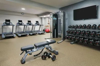 a gym with tread machines and a flat screen tv at DoubleTree by Hilton Orlando Airport Hotel in Orlando