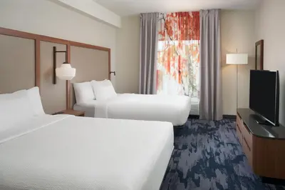 a hotel room with two beds and a flat screen tv at Fairfield Inn & Suites by Marriott Orlando International Drive/Convention Center in Orlando