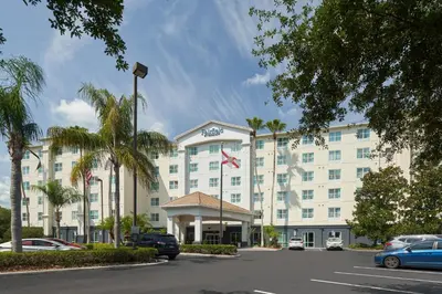 a large white hotel with cars parked in a parking lot at Fairfield Inn & Suites by Marriott Orlando International Drive/Convention Center in Orlando