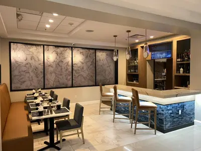 a restaurant with a bar and tables and chairs at Crowne Plaza Orlando-Downtown by IHG in Orlando