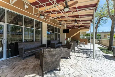 an outdoor patio with benches and tables and windows at Crowne Plaza Orlando-Downtown by IHG in Orlando