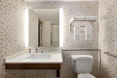 a bathroom with a sink and a toilet and a mirror at Holiday Inn Orlando International Airport by IHG in Orlando