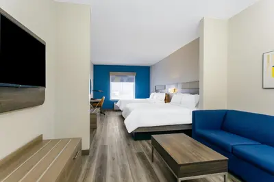 a hotel room with a large bed and a blue couch at Holiday Inn Express Orlando-Ocoee East by IHG in Orlando