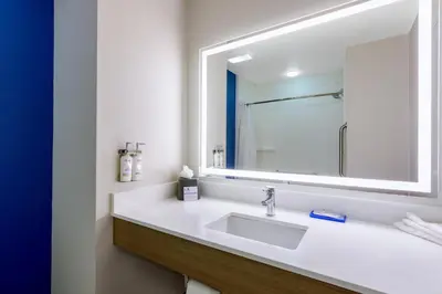 a bathroom with a sink and a mirror at Holiday Inn Express Orlando-Ocoee East by IHG in Orlando