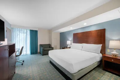 a hotel room with a large bed and a chair at Holiday Inn Orlando – Disney Springs® Area by IHG in Orlando