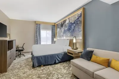 a hotel room with a bed and a couch at Best Western Plus Sanford Airport/Lake Mary Hotel in Sanford