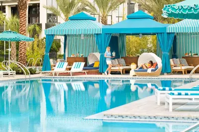 a group of people sitting in chairs by a swimming pool at Hilton Orlando Buena Vista Palace - Disney Springs Area in Orlando