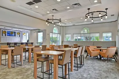 a dining room with tables and chairs and windows at Homewood Suites by Hilton Lake Buena Vista Orlando - Newly Renovated! in Orlando