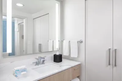 a white bathroom with a sink and a mirror at Homewood Suites by Hilton Lake Buena Vista Orlando - Newly Renovated! in Orlando