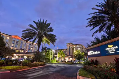 a street in front of a hotel with palm trees at Homewood Suites by Hilton Lake Buena Vista Orlando - Newly Renovated! in Orlando