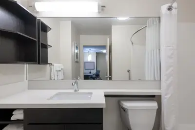a bathroom with a sink and a toilet and a mirror at Candlewood Suites Lake Mary by IHG in Lake Mary