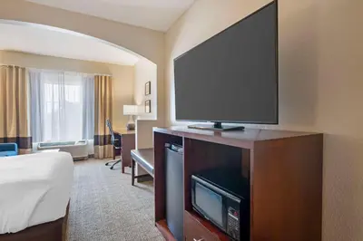 a hotel room with a large flat screen tv at Comfort Suites Downtown in Orlando