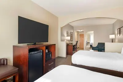 a hotel room with two beds and a flat screen tv at Comfort Suites Downtown in Orlando