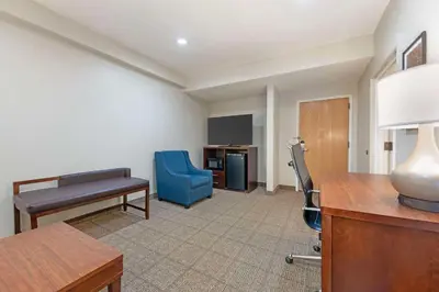 a hotel room with a desk and a blue chair at Comfort Suites Downtown in Orlando