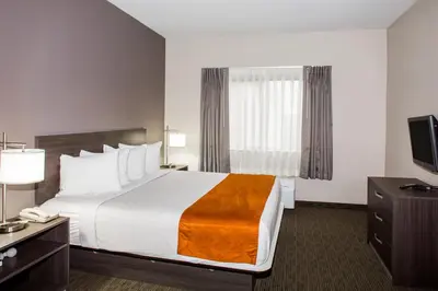 a hotel room with a bed and a television at Days Inn & Suites by Wyndham Orlando Airport in Orlando