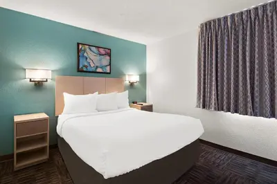 a hotel room with a large bed with white sheets at MainStay Suites Orlando Altamonte Springs in Orlando