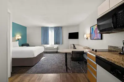 a hotel room with a bed and a kitchen at MainStay Suites Orlando Altamonte Springs in Orlando