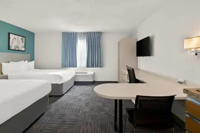 a hotel room with two beds and a table at MainStay Suites Orlando Altamonte Springs in Orlando