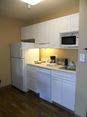 a kitchen with white cabinets and a white refrigerator at Extended Stay America Suites - Orlando - Convention Center - Universal Blvd in Orlando