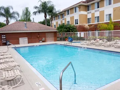 a large swimming pool with chairs and a building at Extended Stay America Suites - Orlando - Convention Center - Universal Blvd in Orlando