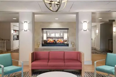 a waiting room with a red couch and a fireplace at Homewood Suites by Hilton Lake Mary Orlando North in Lake Mary