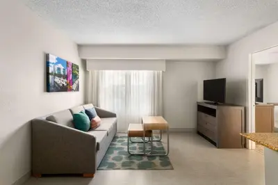 a living room with a couch and a tv at Homewood Suites by Hilton Lake Mary Orlando North in Lake Mary