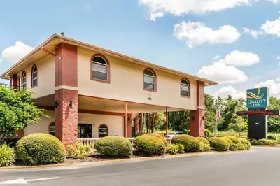 a hotel with a sign in front of a building at Quality Inn & Suites Orlando Airport in Orlando