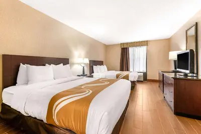 a hotel room with two beds and a flat screen tv at Quality Inn & Suites Orlando Airport in Orlando