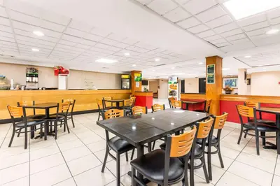 a dining room with tables and chairs in a restaurant at Quality Inn & Suites Orlando Airport in Orlando